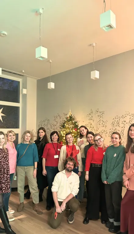 Praktykanci i koordynator praktyk pod choinką w poczekalni Poradni